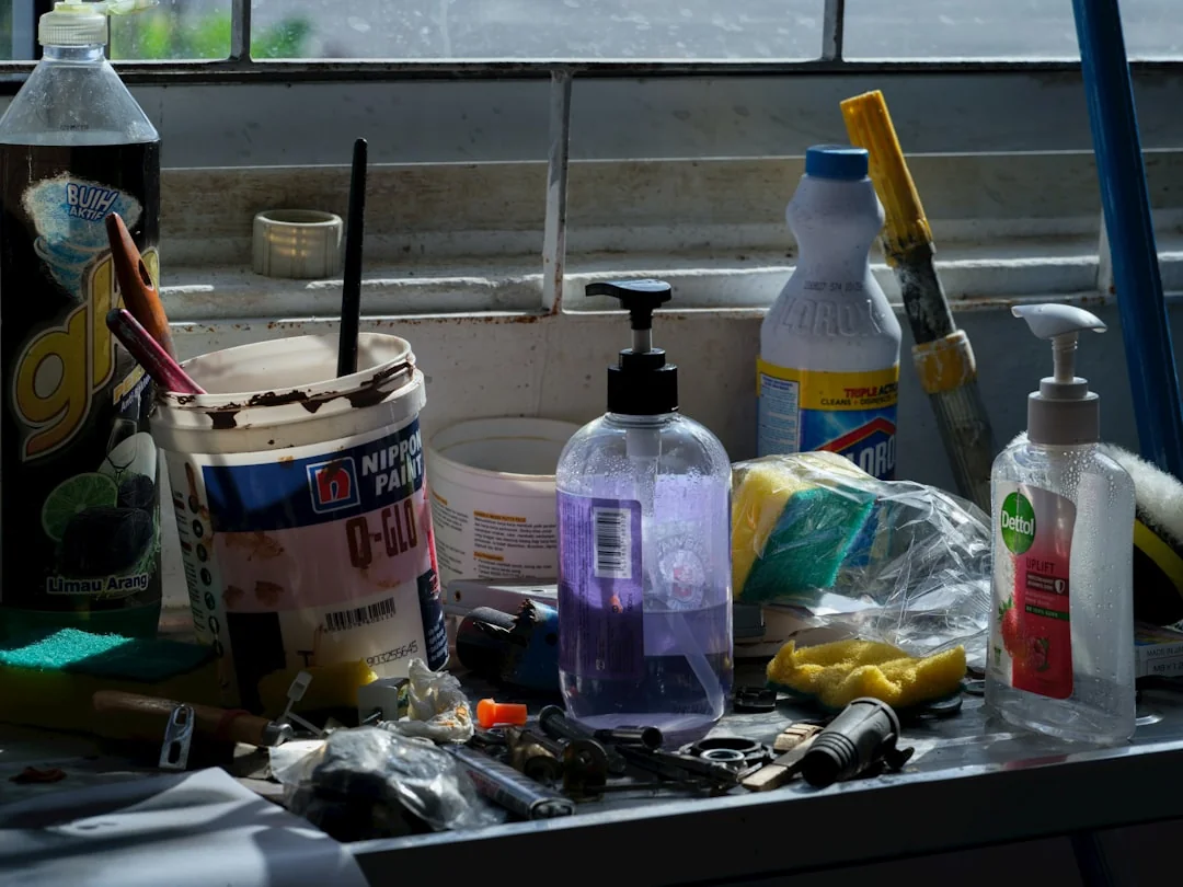 A woman cleans a mirror indoors using a blue cloth, reflecting cleanliness and home care.